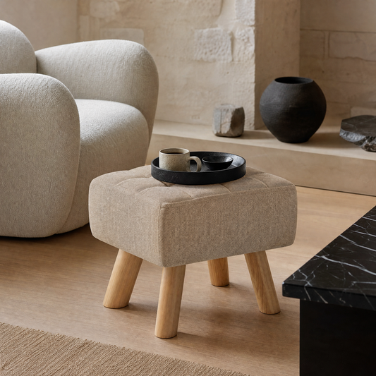 Pouf repose-pieds rembourré devant un fauteuil