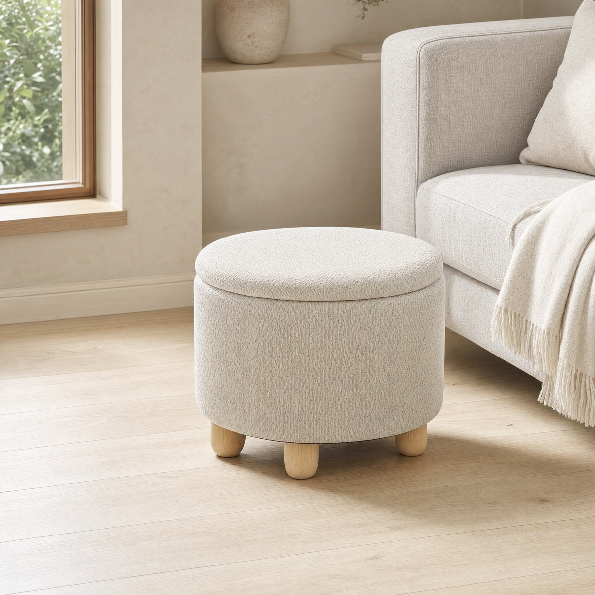 Pouf coffre rond effet jute beige à pieds en bois dans un salon
