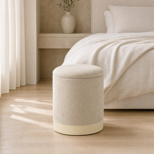 Pouf coffre rond en chenille beige au pied d'un lit