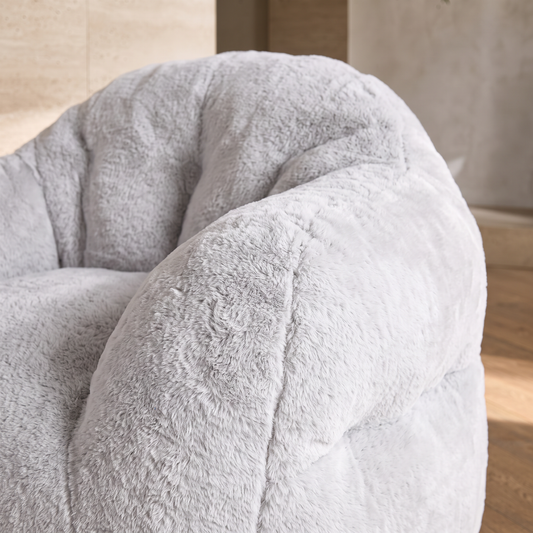 Gros plan sur l'accoudoir rembourré et la fausse fourrure du pouf poire XXL