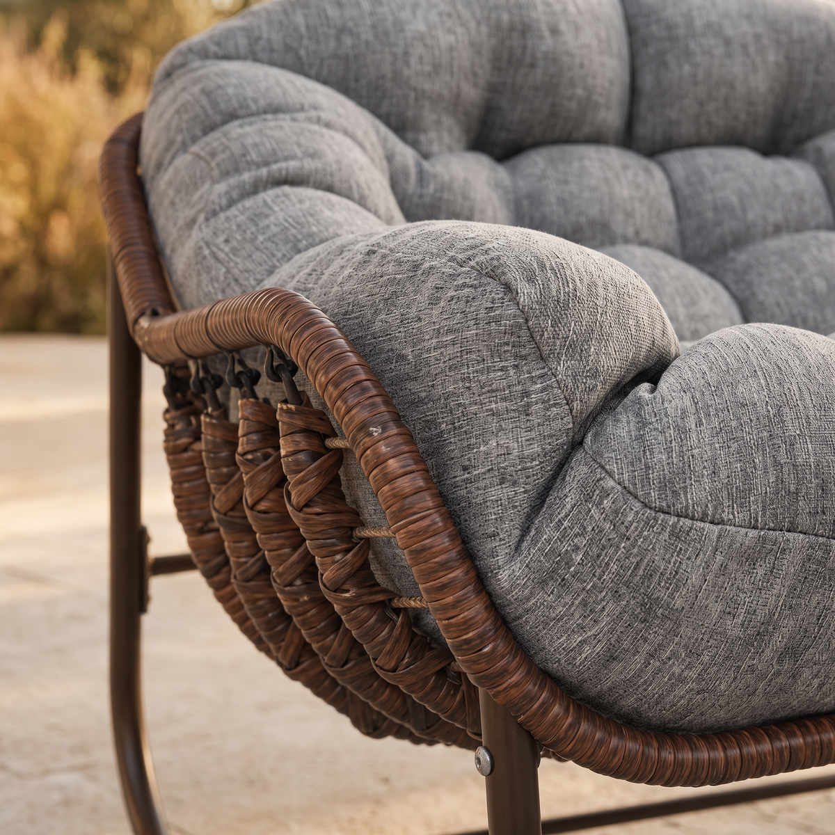 Gros plan sur le tressage de la coque et l'épaisseur du coussin du fauteuil papasan