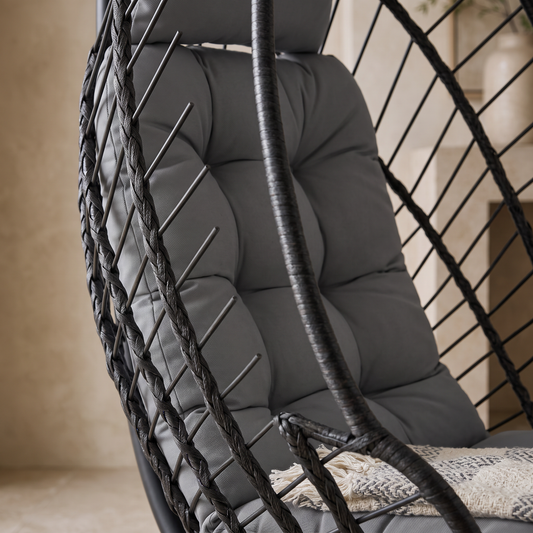 Gros plan sur le panier tressé et le coussin épais du fauteuil œuf suspendu