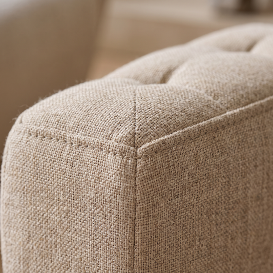 Gros plan sur les surpiqûres et la texture du tissu du pouf repose-pieds